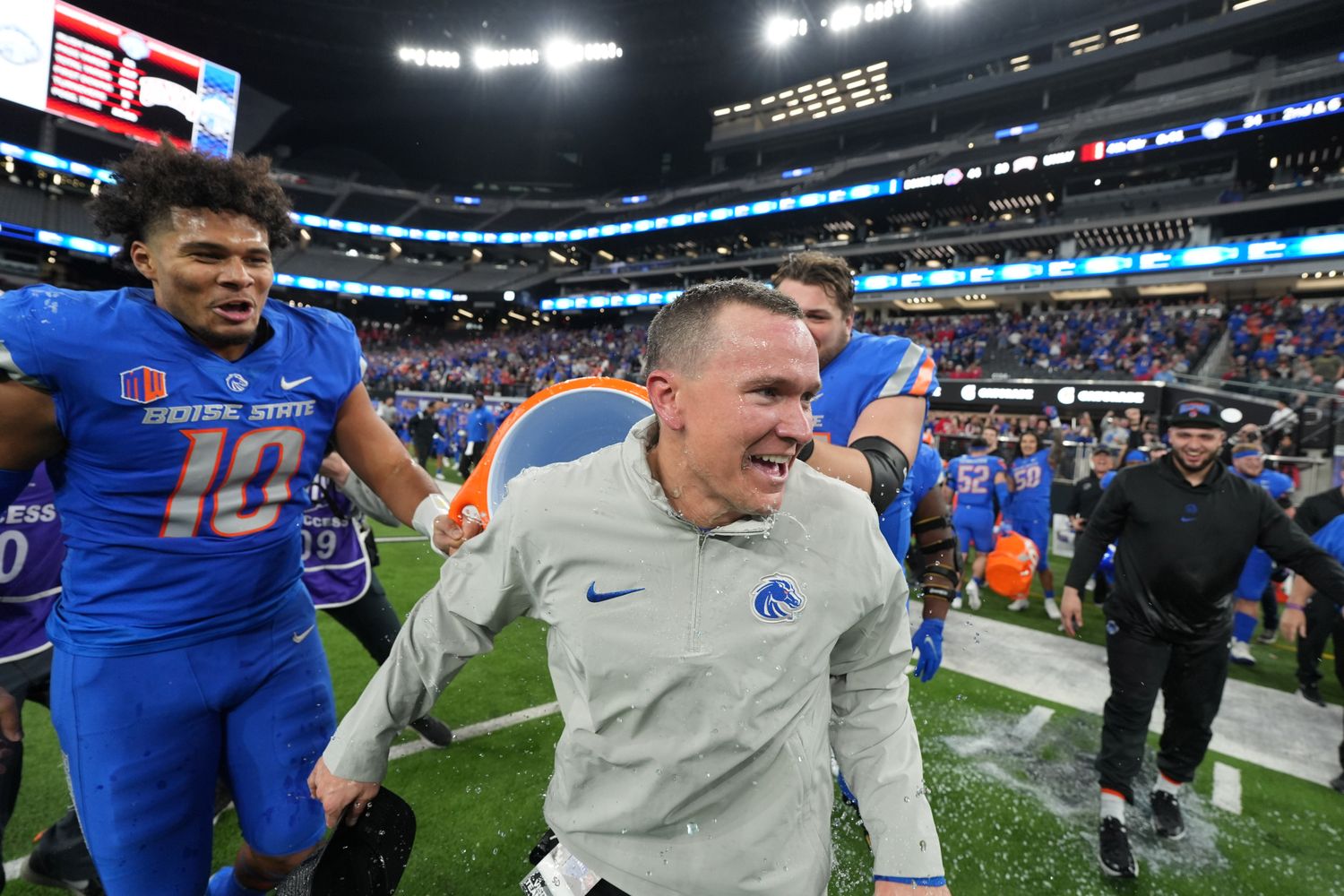 Spencer Danielson runs as Boise State players lift a gatorade cooler to dump on him